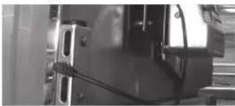 Close-up of a mechanical component with visible brackets and mounting holes, no text or symbols.