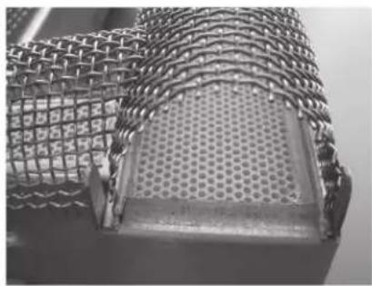 Close-up of a metal mesh structure with a perforated interior panel, no text or symbols visible.