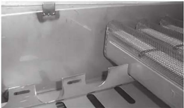 Close-up of a metallic mechanical component with internal mesh structure and mounting brackets (no visible text or symbols)