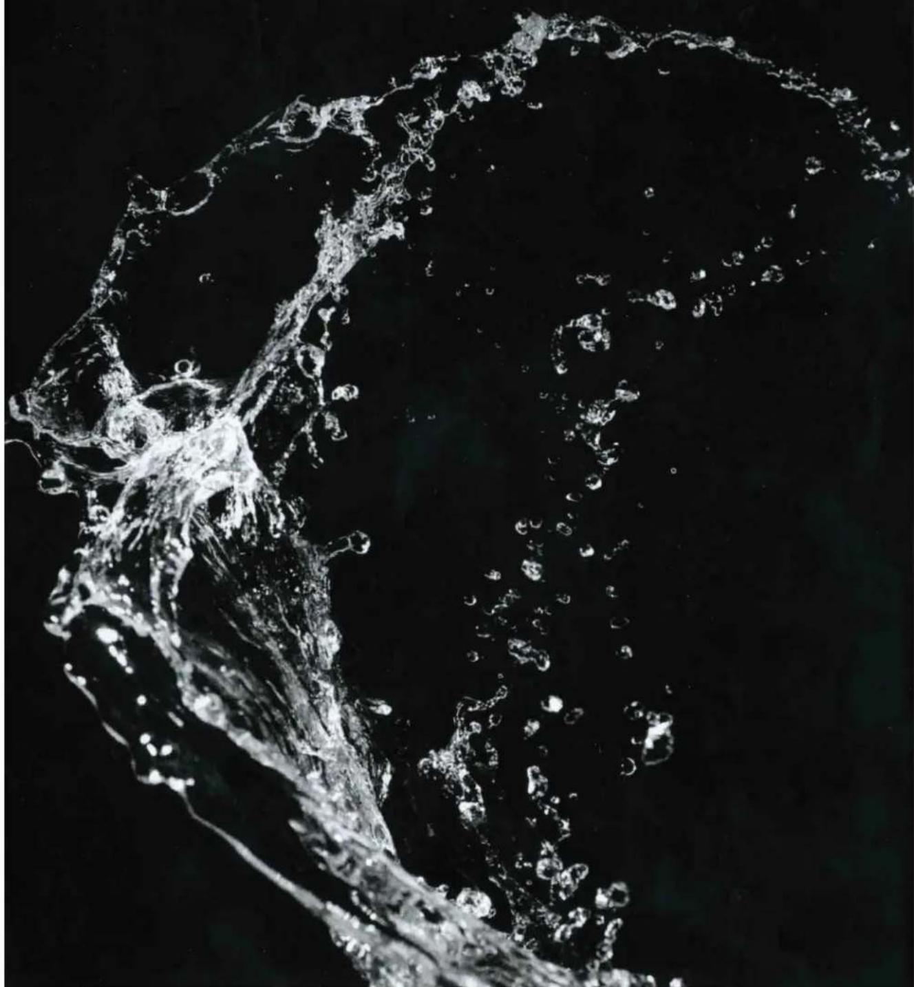 Black-and-white close-up of a splashing water splash against a dark background (no text or symbols)