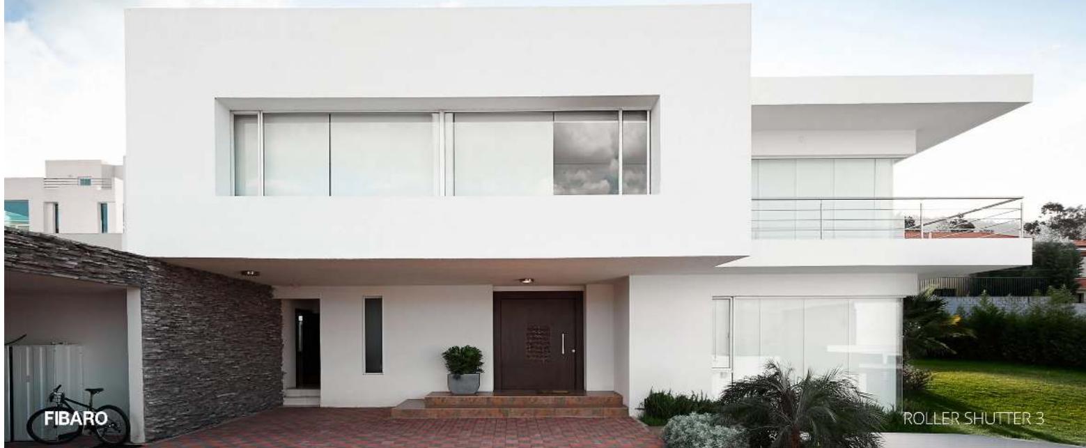 Exterior view of a modern white two-story house with a brick entrance and landscaping (no signage)