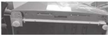 Close-up of a mechanical component with mounting holes and a central rectangular block (no visible text or symbols).