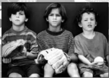 Black-and-white photo of three boys sitting together, one holding a baseball glove (no text or symbols visible).