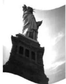 Black-and-white photo of the Statue of Liberty with a sculpted figure atop it, no visible text or symbols.