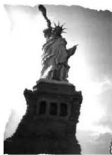 Black-and-white photo of the Statue of Liberty on a pedestal, no visible text or symbols.