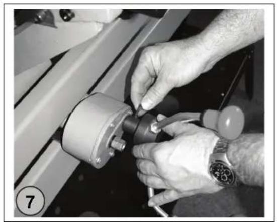 Close-up of hands adjusting a mechanical component with a watch (no visible text or symbols)