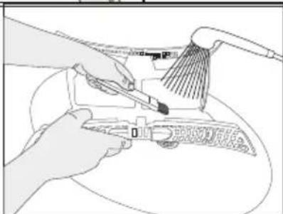 Line drawing of hands using a power tool to clean or adjust equipment (no text or symbols visible)