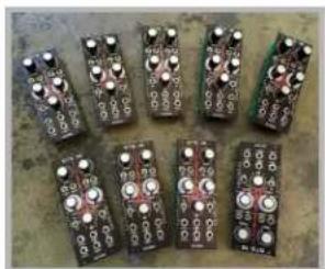 Seven electronic circuit boards arranged in a grid, no visible text or symbols on the boards themselves.