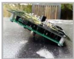 Close-up of a damaged electronic circuit board with visible traces and components (no text or symbols)