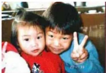 Two children making peace signs together, one making a peace sign (no visible text or symbols)