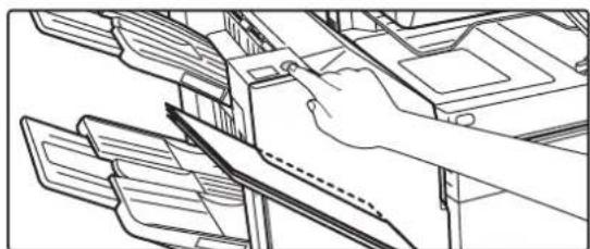 Line drawing of a hand inserting a folder into a device (no text or symbols).