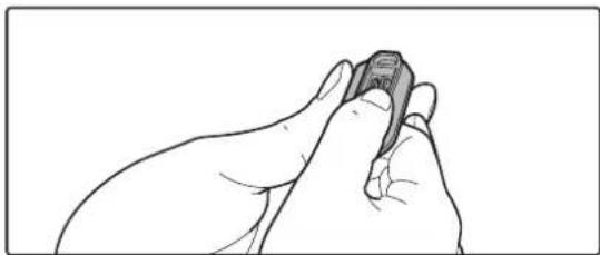 Line drawing of a hand holding a small object, possibly a tool or device, with no visible text or symbols.