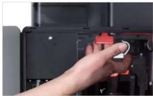 Close-up of a hand inserting a small component into a black electronic device casing.