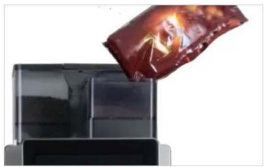 Close-up of a chocolate bag being poured into a black container (no text or symbols visible)
