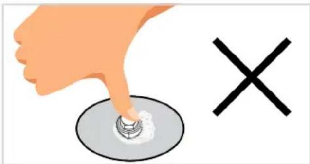 Illustration showing a hand pressing a button on a circular object with a cross symbol nearby.