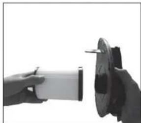 Close-up of a hand holding a small mechanical component next to a circular mechanical part (no visible text or symbols)