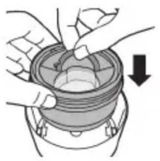 Illustration of hands assembling a mechanical component with a downward arrow indicating motion (no text or symbols).