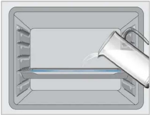 Illustration of a container with a glass pitcher pouring liquid into it (no text or symbols)
