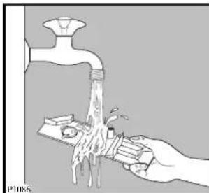 Illustration of a hand using a tool to clean water from a faucet, with no text or symbols present.