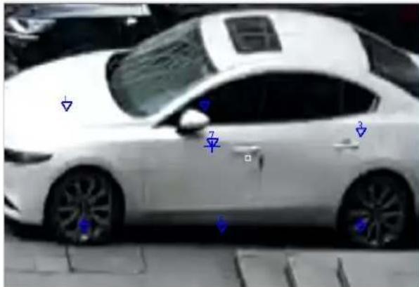 Street photo of a white car with blue directional arrows and numbered markers indicating specific positions or features.