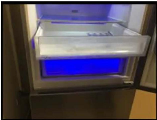 Interior view of a refrigerator with a blue-lit rack and open door (no visible text or symbols)
