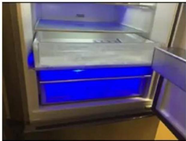 Interior view of a refrigerator with blue liquid and open door (no visible text or symbols)
