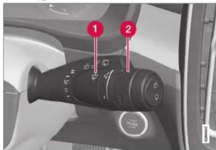 Car interior control panel with labeled buttons and a rotary dial indicator