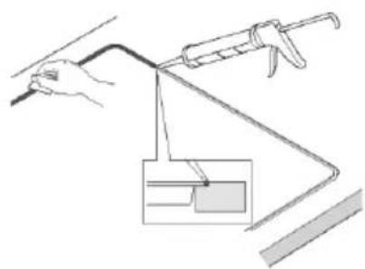 Line drawing of a hand using a tool to lift a curved pipe, with an inset showing a component (no text or symbols)