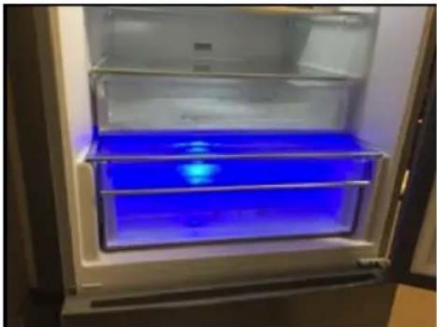 Interior view of a refrigerator with blue liquid inside the door (no text or symbols visible)