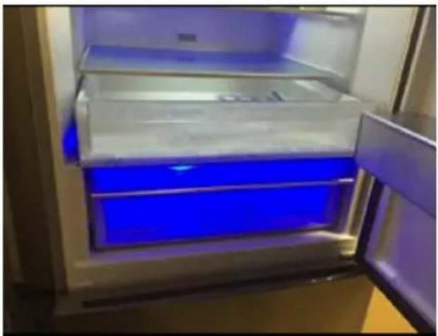 Interior view of a refrigerator with blue-lit doors and open door (no visible text or symbols)