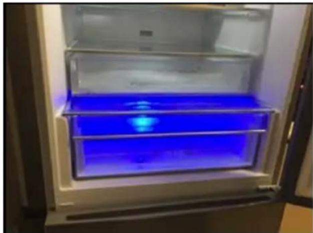 Interior view of a refrigerator with blue liquid inside the door (no text or symbols visible)