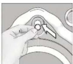 Close-up of a hand pressing a button on a curved mechanical component (no visible text or symbols)