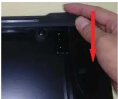 Close-up of a hand holding a black electronic component with a red arrow pointing to a small component (no visible text or symbols).