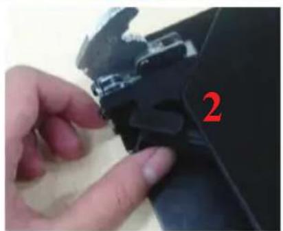 Close-up of a hand adjusting a black plastic component with a red number '2' on the side (no text or symbols on the object itself).