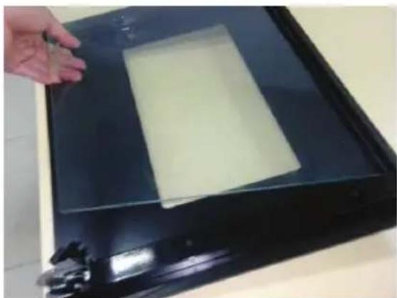 Hand placing a yellow rectangular object on a black rectangular base, no visible text or symbols.