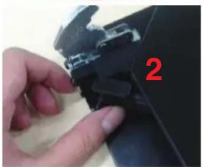 Close-up of a hand adjusting a black mechanical component with a red number '2' on the side.