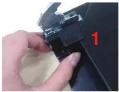 Close-up of a hand adjusting a black plastic clip with a red number '1' on the handle.