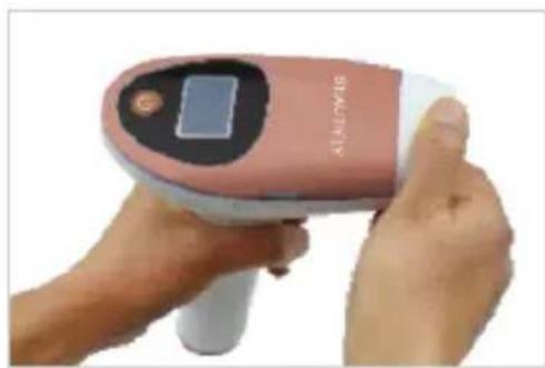 Close-up of a pink handheld medical or cosmetic device with a digital display, being handled by hands (no visible text or symbols)