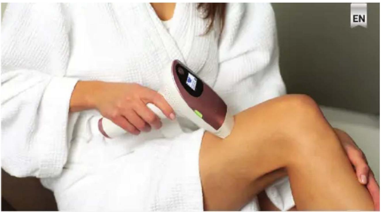 Person in white robe using a medical device on a seated leg, no visible text or symbols