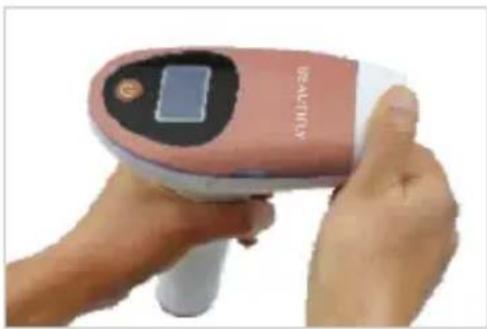 Close-up of a handheld medical or cosmetic device with a pink and white body, no visible text or symbols on the device itself.