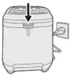 Line drawing of a kitchen appliance with a downward arrow indicating a drop or compression point (no text or symbols)