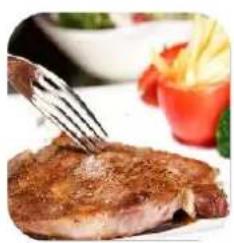 Close-up of a golden-brown steak being cut with a fork, accompanied by a colorful salad bowl and garnish.