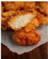 Close-up of golden-brown fried food items with a cut open, placed on parchment paper, no text or symbols visible.