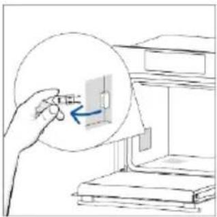 Illustration of a hand inserting a small object into a device inside a circular frame, with no visible text or symbols.