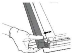 Hand holding a mechanical component with a ruler and guide rails (no text or symbols visible)