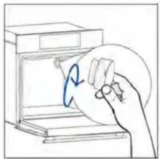 Hand holding a circular object with a blue arrow inside, next to an open appliance (no text or symbols visible)