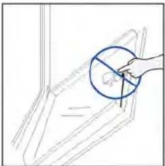 Hand holding a blue circle with a diagonal line intersecting it, pointing to a small object on a curved surface (no text or symbols present)
