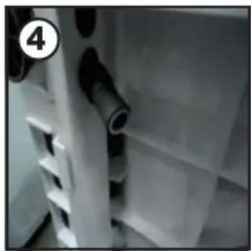 Close-up of a white plastic shelf with black cylindrical objects, no visible text or symbols