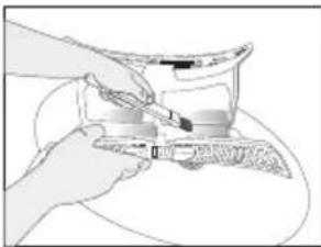 Illustration of hands using a tool to cut or spread a cylindrical object (no text or symbols visible)