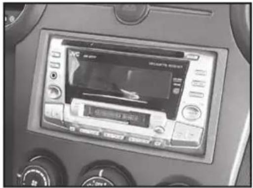 Interior view of a car dashboard with a digital display showing a screen and control buttons (no readable text or symbols)